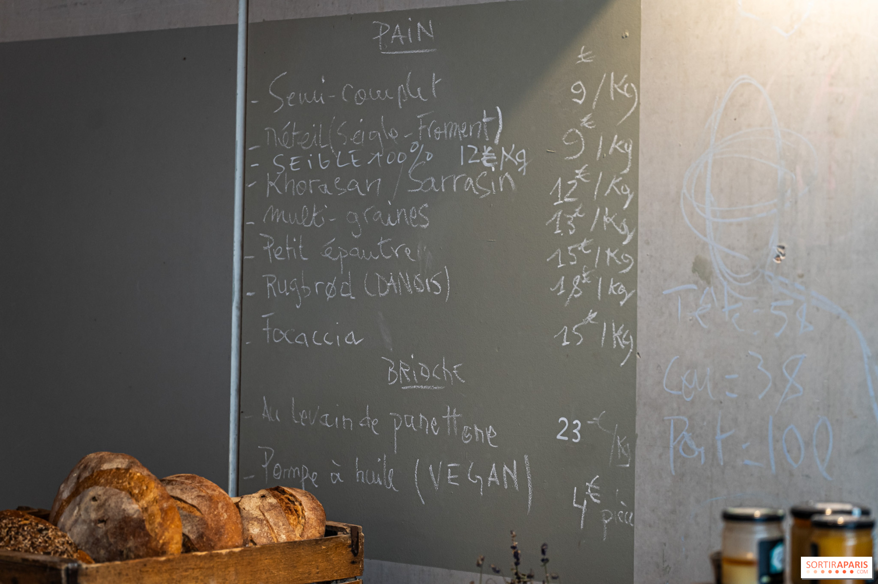 L'ardoise de la boutique avec les prix des pains et brioches au poids